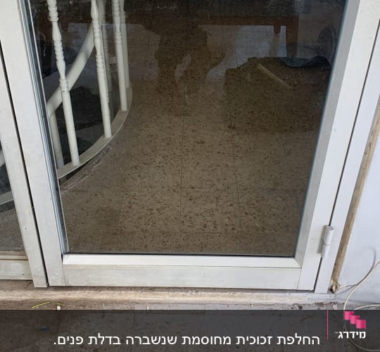 דלת זכוכית עם מסגרת מתכת ולכלוך על הזכוכית